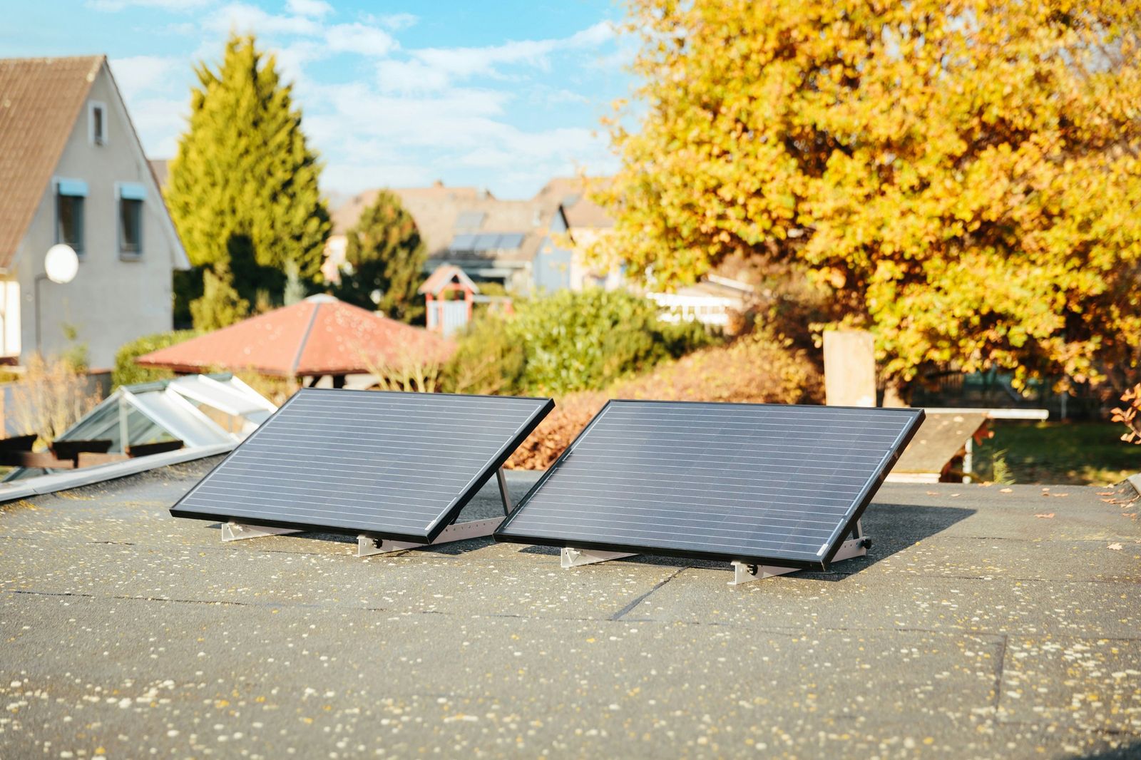 Two tilted solar panels on a flat roof on a sunny day
