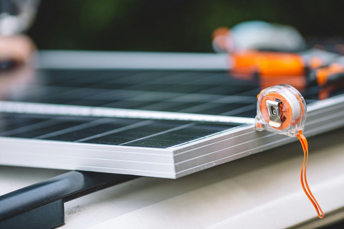 Tape measure resting on the aluminum frame of a solar panel