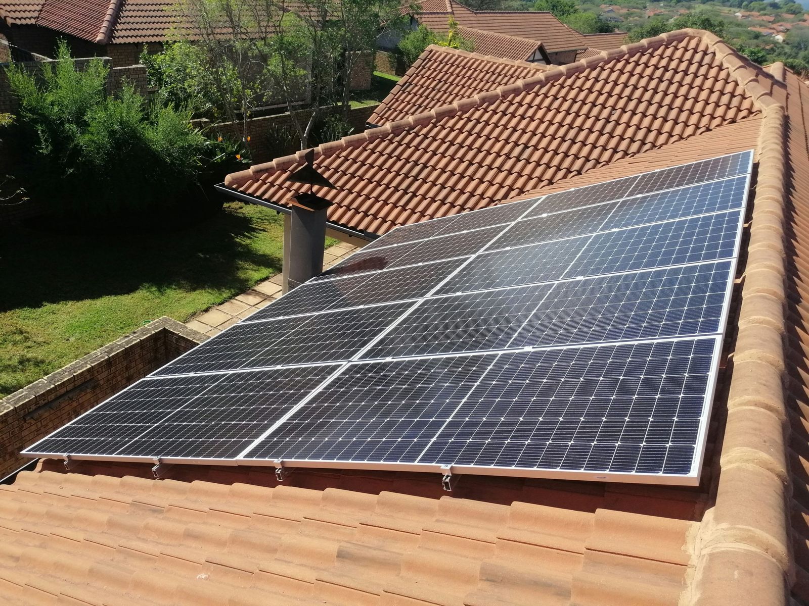 Monocrystalline solar panels mounted on a terracotta tile roof